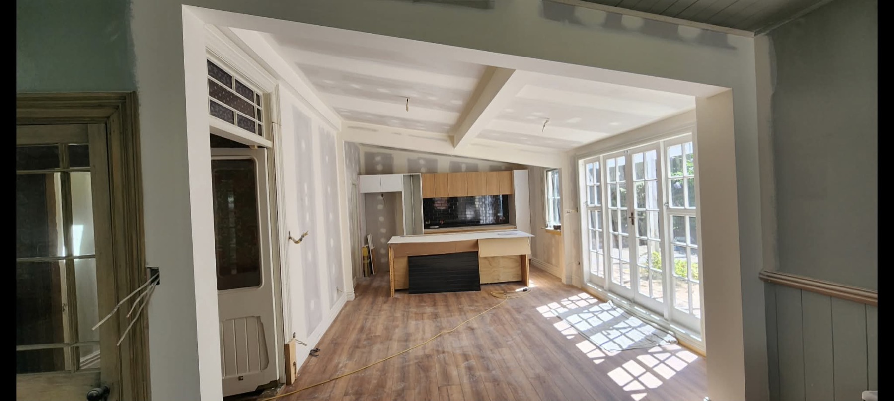 Character home renovation with stopped plasterboard walls, ceiling work, timber floors, and original windows.